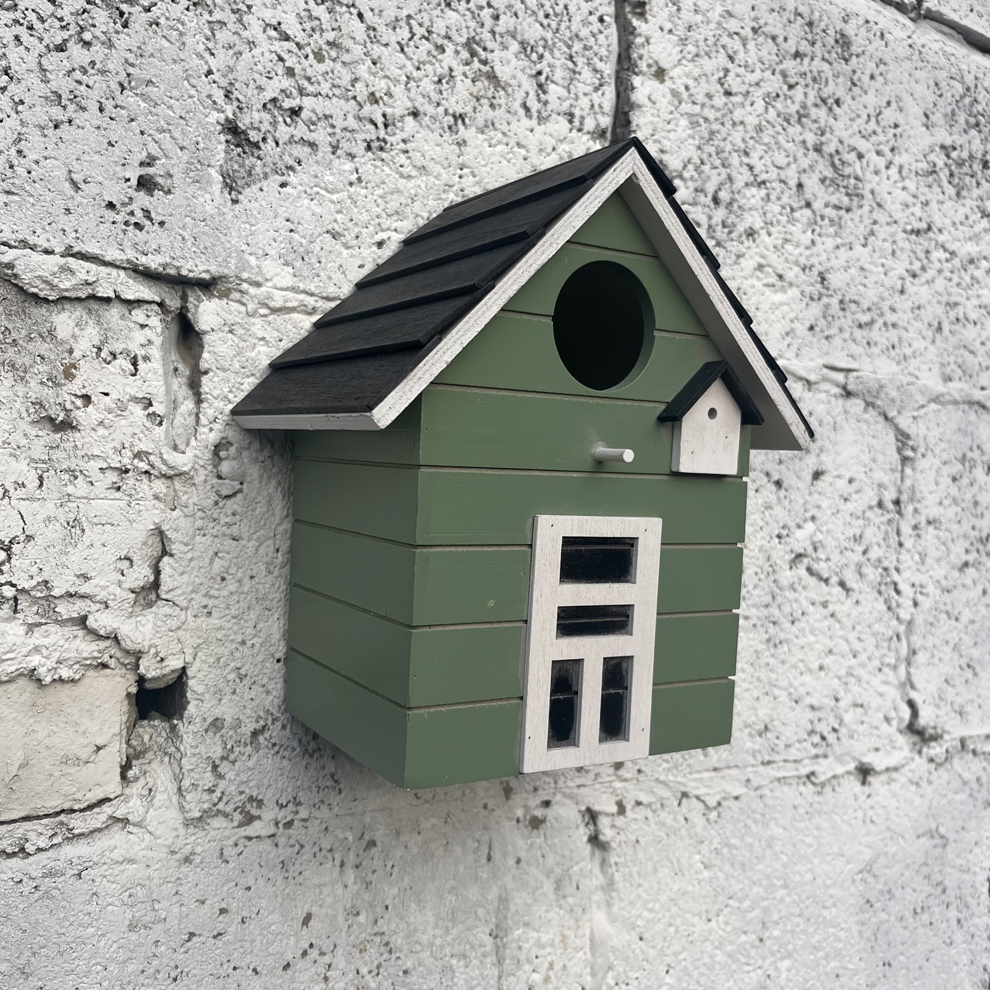 Nichoir coloré Spring Melody en bois léger suspendu dans un jardin fleuri, accueillant des mésanges et des bleuets.