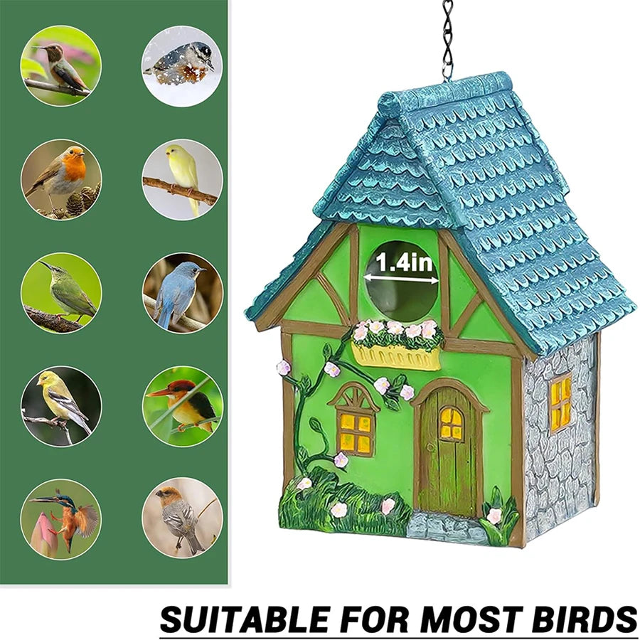 Nichoir suspendu en résine Nest-oo Jardin Bohème, suspendu à une chaîne noire dans un jardin verdoyant.